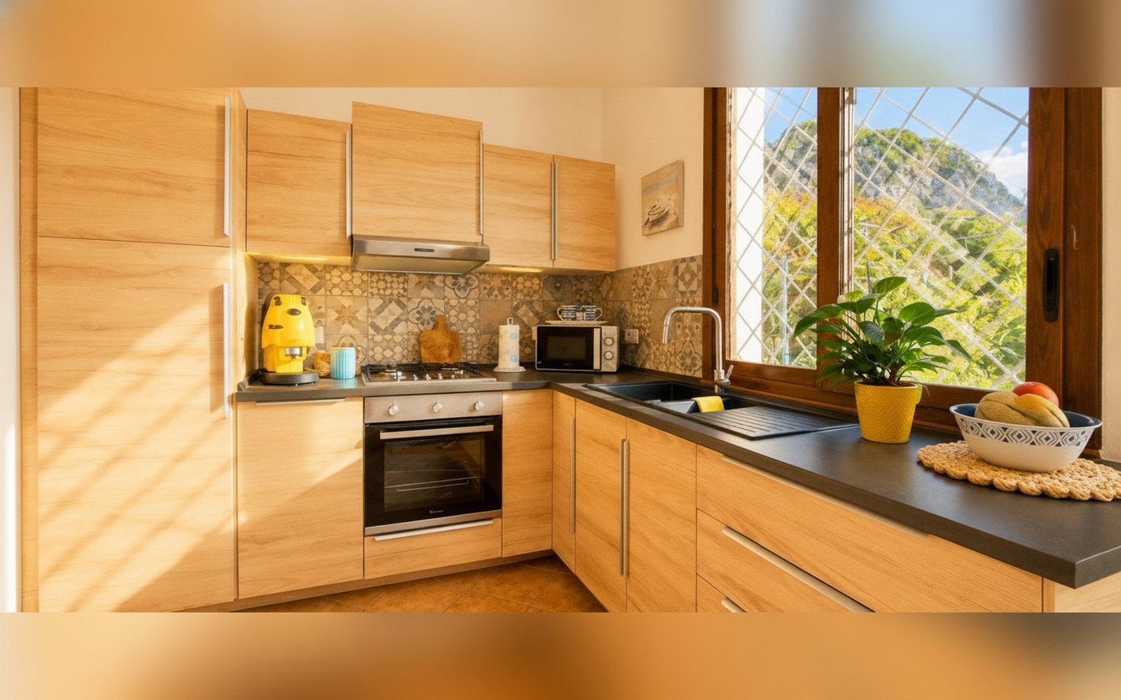 La cucina della villa con top scuro e finestra sul verde