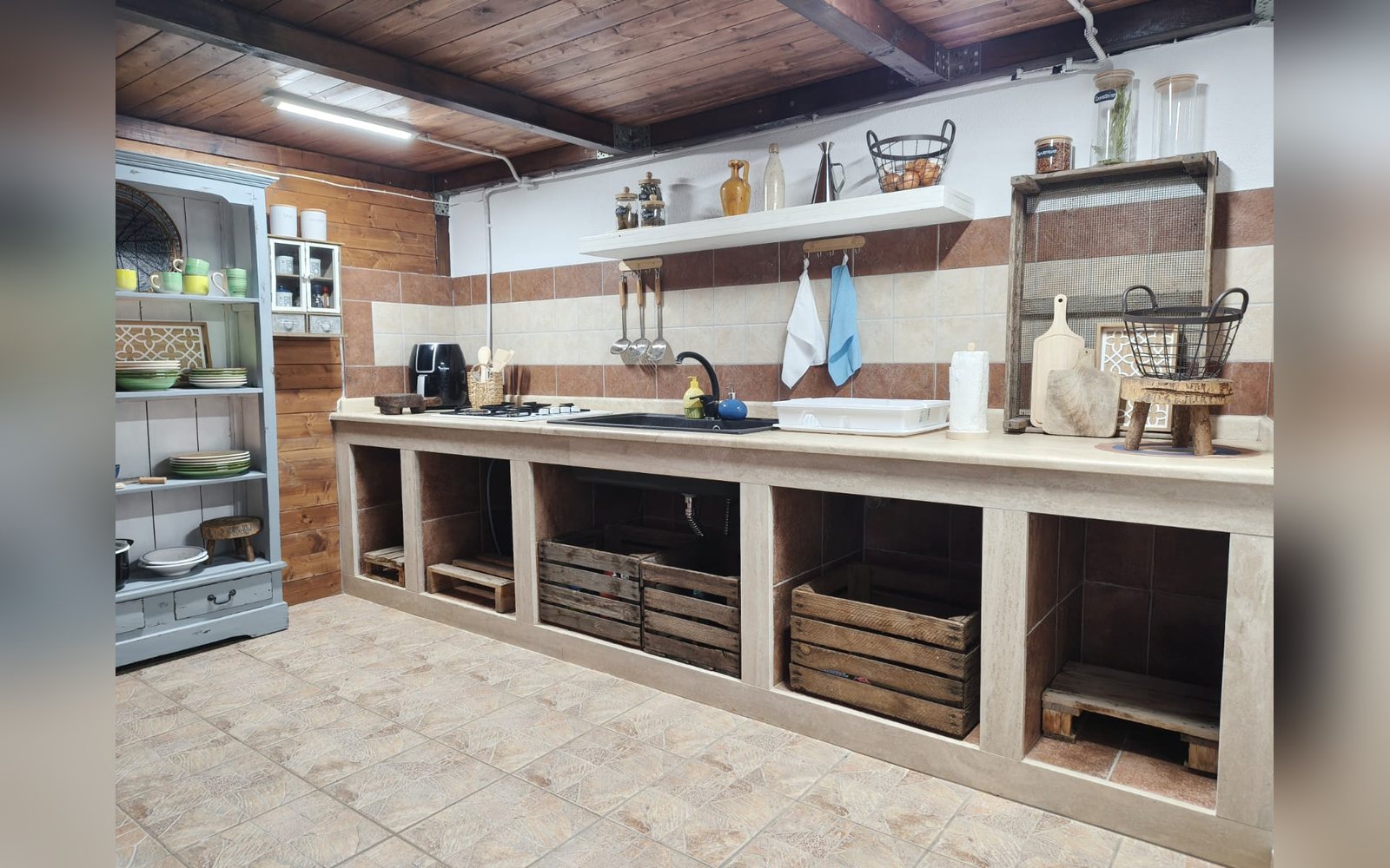 La cucina esterna attrezzata con lavello, mensole e barbecue